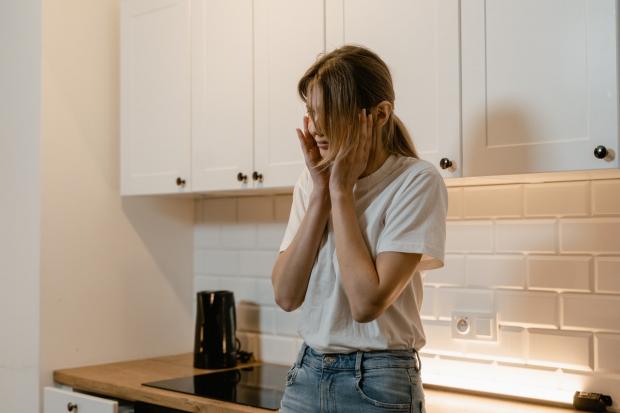 girl standing in the kitchen with her hands on her head